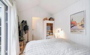 A bedroom with a bed, a wardrobe, and a door leading to a balcony. - House decorated in a classic style, near the water (Ebeltoft)