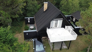 A black house with a white balcony, surrounded by greenery. - House decorated in a classic style, near the water (Ebeltoft)