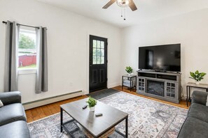 A living room with a television, a coffee table, and two sofas. - The Hilltop Farmhouse — A Private Country Retreat (Madison)
