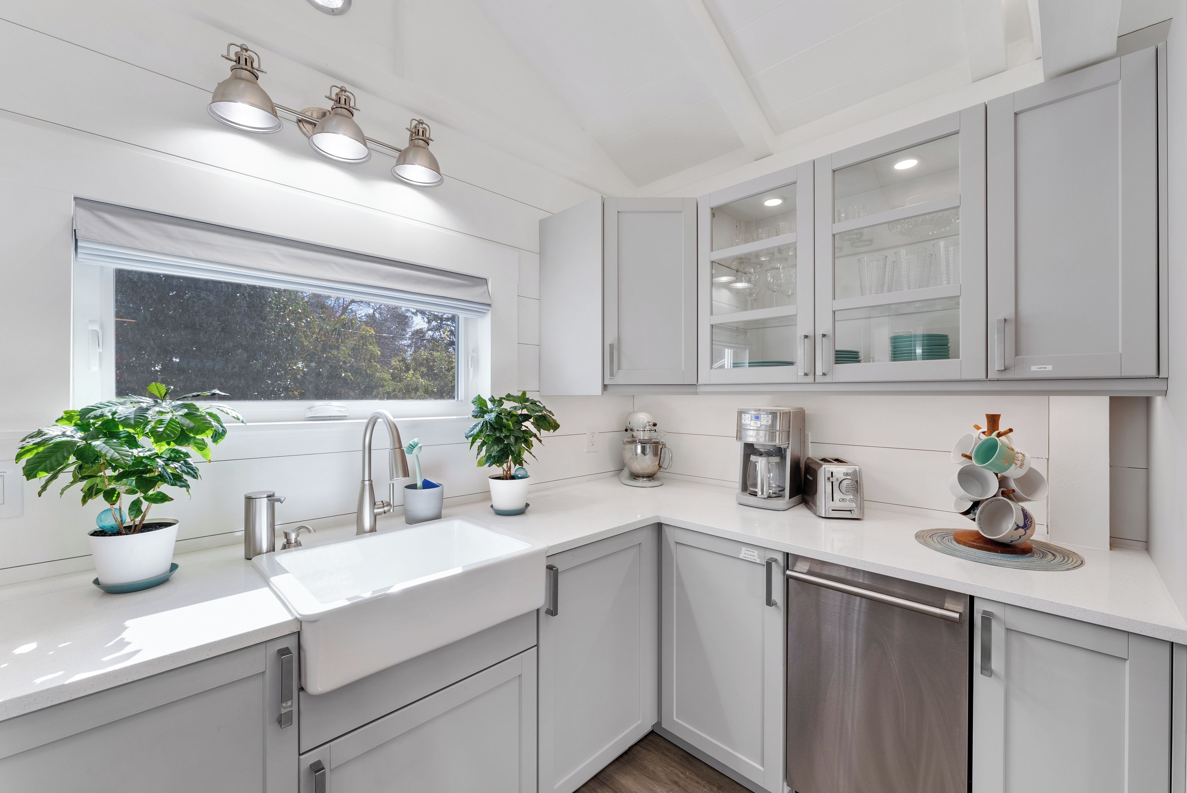 Una cocina moderna con un lavamanos, armarios y una ventana.