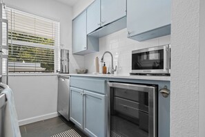 A compact kitchen with a dishwasher, a microwave, and a built-in oven. - Chic Clarksville Condo w/ Covered Patio & Gated Keypad Entry - Near Downtown (Austin)