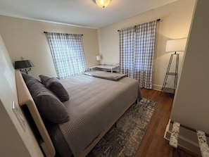 A bedroom with a bed, bedside tables, a desk, and a lamp. - Spacious 4-bedroom house in Graham: Hot tub, Pool, Dog-friendly w/fenced yard (Graham)