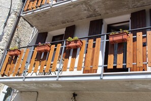 A balcony with wooden railings and multiple flower boxes.