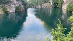 Une rivière paisible, bordée de falaises et de verdure.