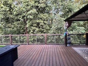 Eine Holzterrasse mit Geländer, einer Pergola und einem mehrstufigen Wasserspiel.