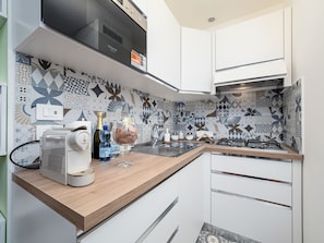 Een moderne keuken met een magnetron, broodrooster en een gasfornuis.