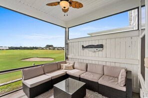 A covered outdoor seating area with a view of a golf course. - Barefoot Resort Getaway | Golf, Pool & Beach (North Myrtle Beach)