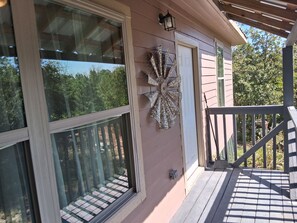 A house with large windows, a decorative wall piece, and a wooden deck.