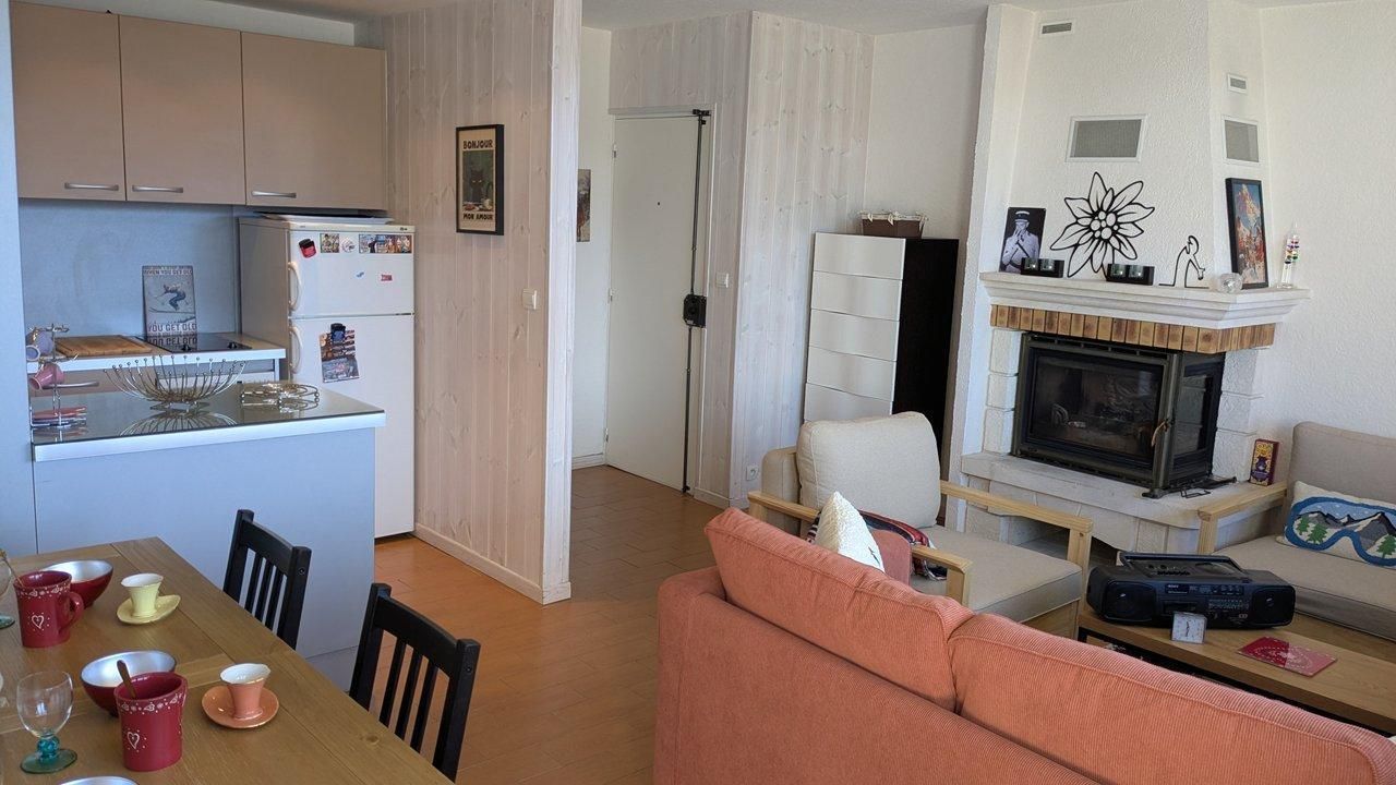 Un espacio habitable funcional con cocina, comedor y chimenea.