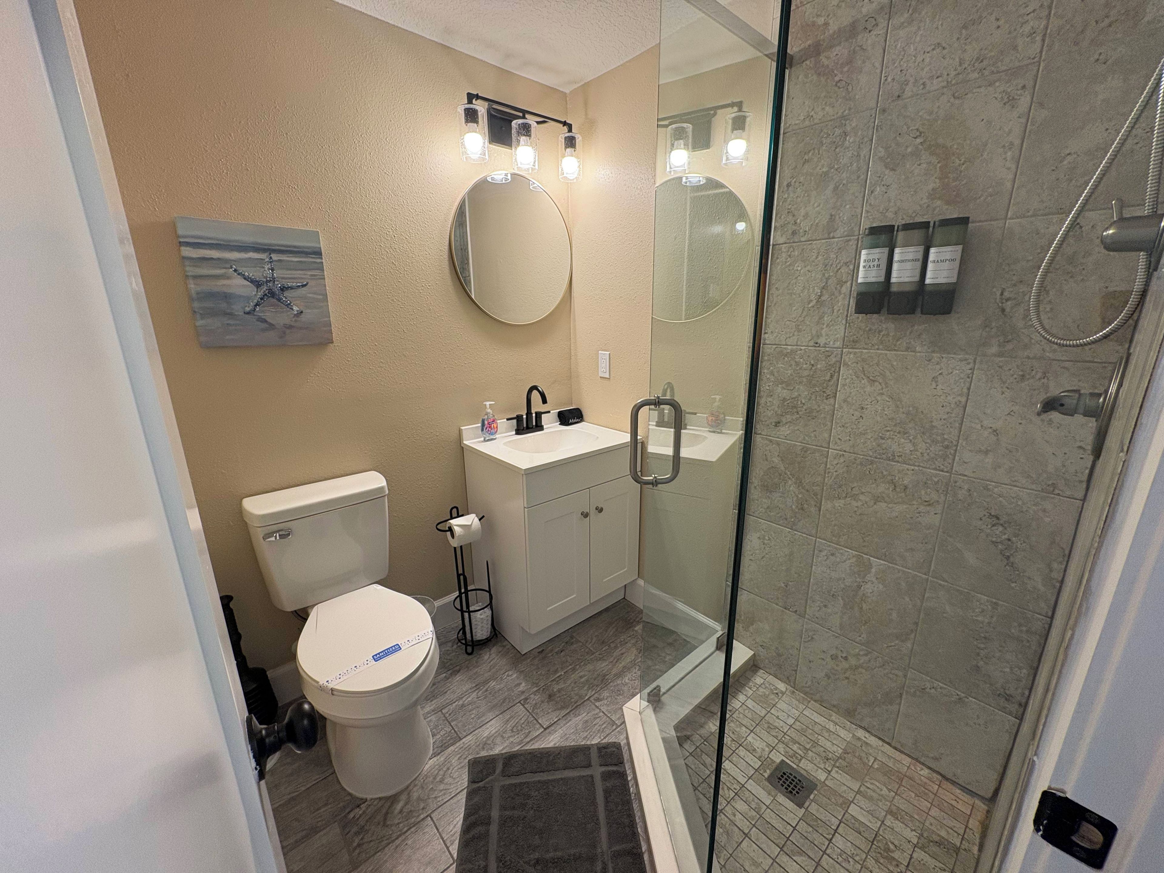 A bathroom with a toilet, sink, and shower.