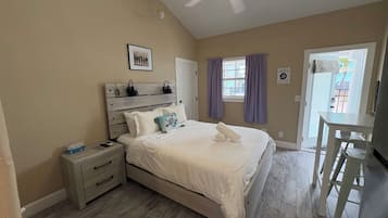 A bedroom with a bed, nightstand, and a ceiling fan.