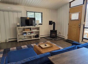 Una sala de estar acogedora con televisión, chimenea y sofá.
