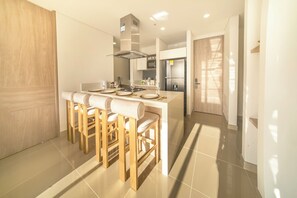 A modern kitchen with a central island, bar stools, and a built-in oven. - Cozy 2-bedroom apartment with Ocean View Reserva Del Mar 2 (Gaira)