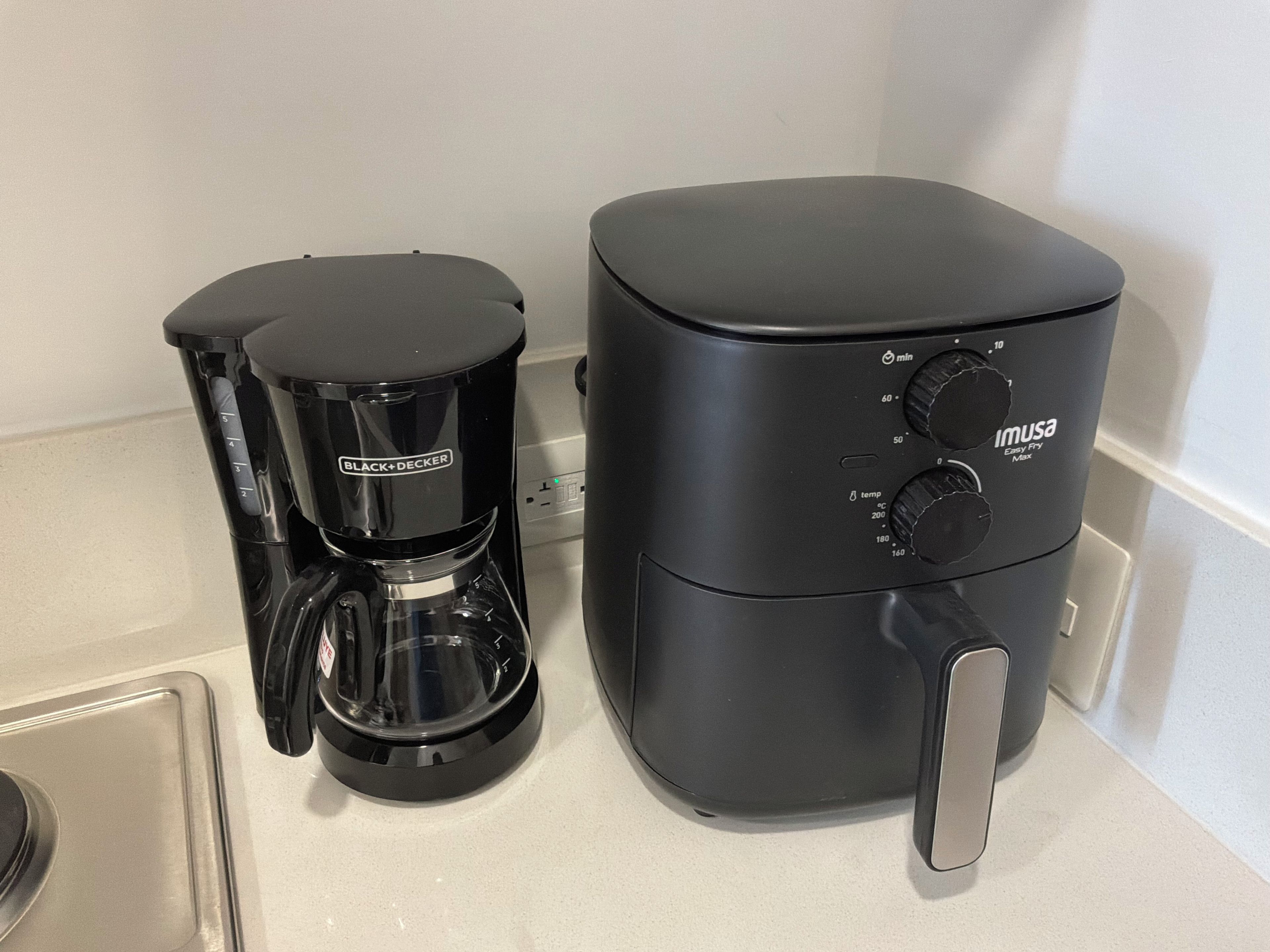 Een koffiezetapparaat en een rijstkoker op een aanrecht.