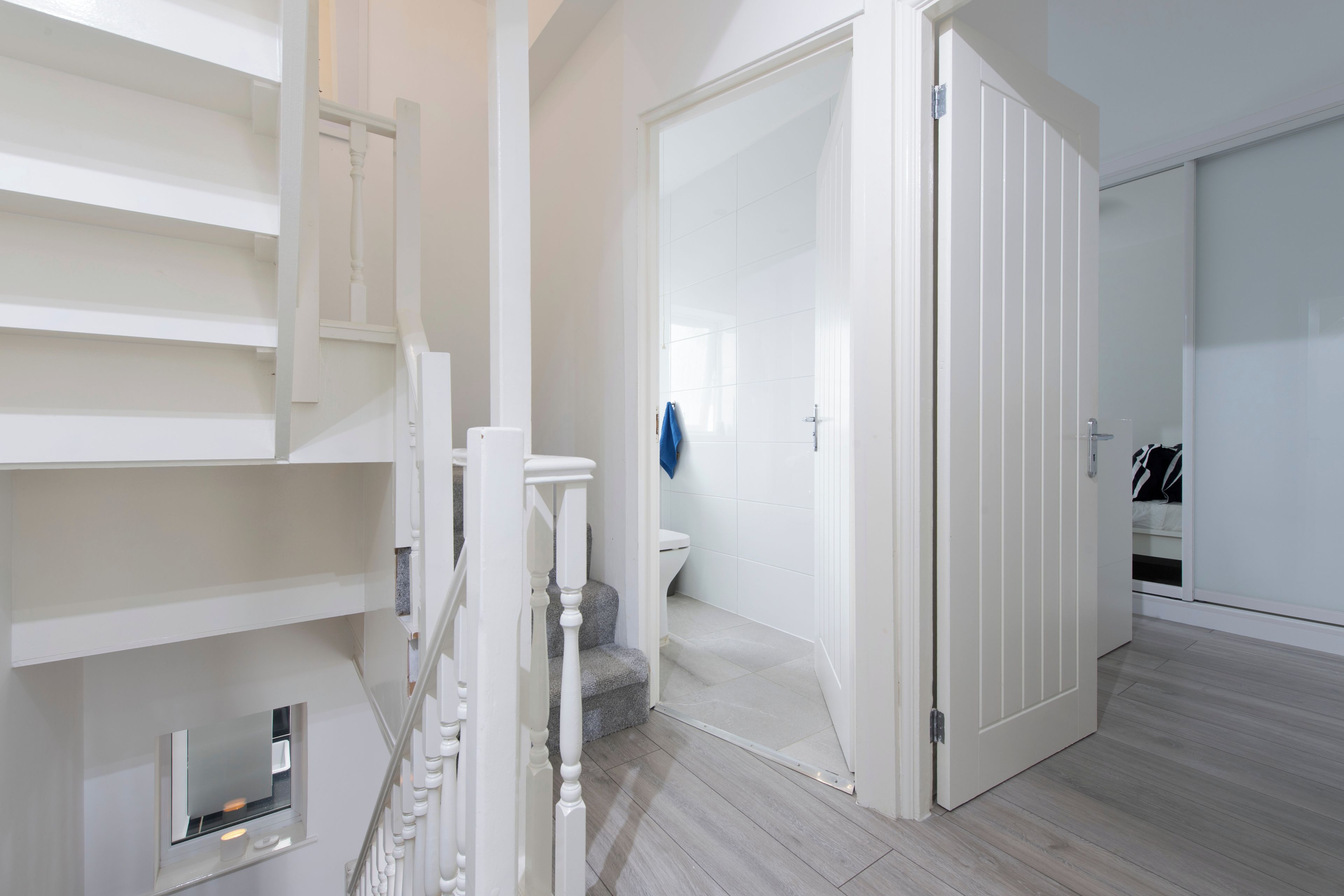 A modern interior with a staircase, a bathroom, and a wardrobe.