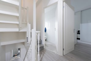 Ein modernes Interieur mit Treppe, Badezimmer und Kleiderschrank.