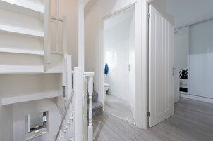 Un interior moderno con una escalera, un baño y un armario.