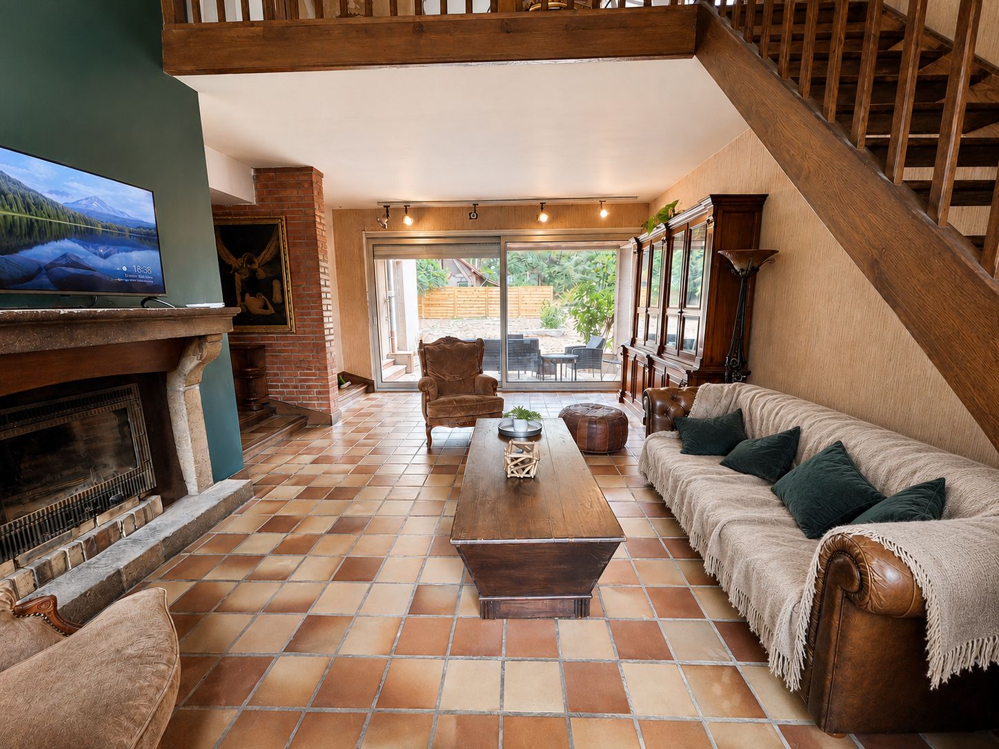A spacious living area with a fireplace, a sofa, a coffee table, and a television.