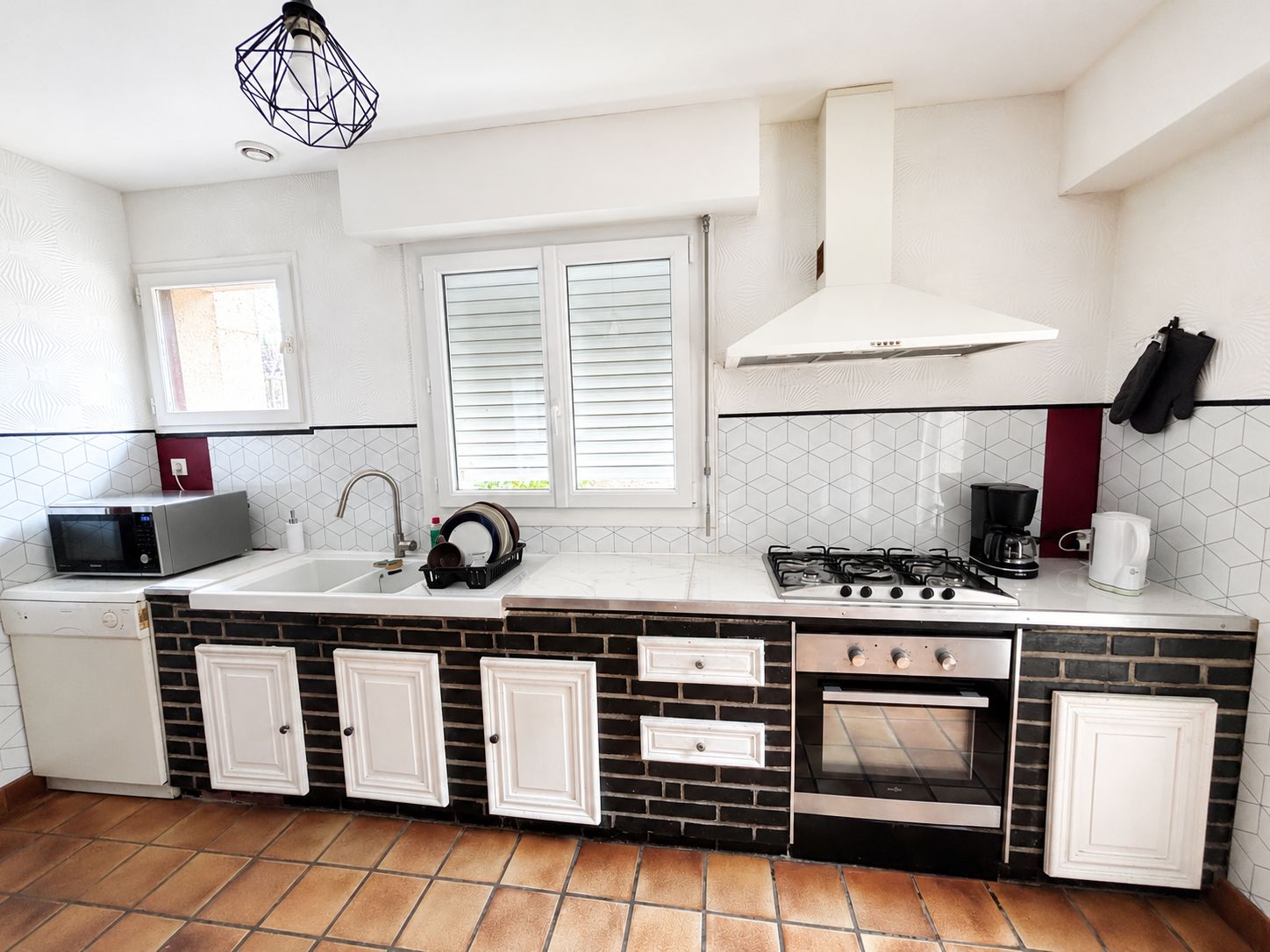 A compact kitchen with a microwave, sink, stove, and oven.