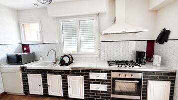 A compact kitchen with a microwave, sink, stove, and oven.