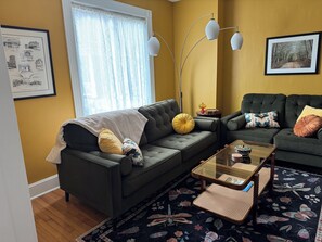 Un salon avec un canapé, une table basse et un tapis à motifs.