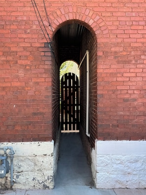 A brick tunnel with a wooden gate at the end.