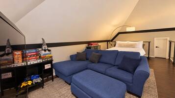 Un dormitorio estilo loft moderno con sofá seccional, cama y equipo de juego.
