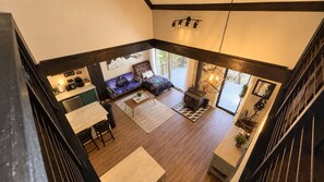 A spacious living area with a fireplace, a sofa, and a dining table.