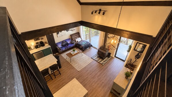 A spacious living area with a fireplace, a sofa, and a dining table.