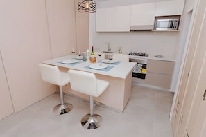 Eine moderne Küche mit einer zentralen Kochinsel, zwei Barhocker, einer Mikrowelle und einem Spülbecken.