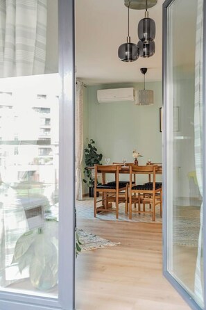 Ein Essbereich mit Holztisch und Stühlen, einer Hängelampe und einem Blumentopf.