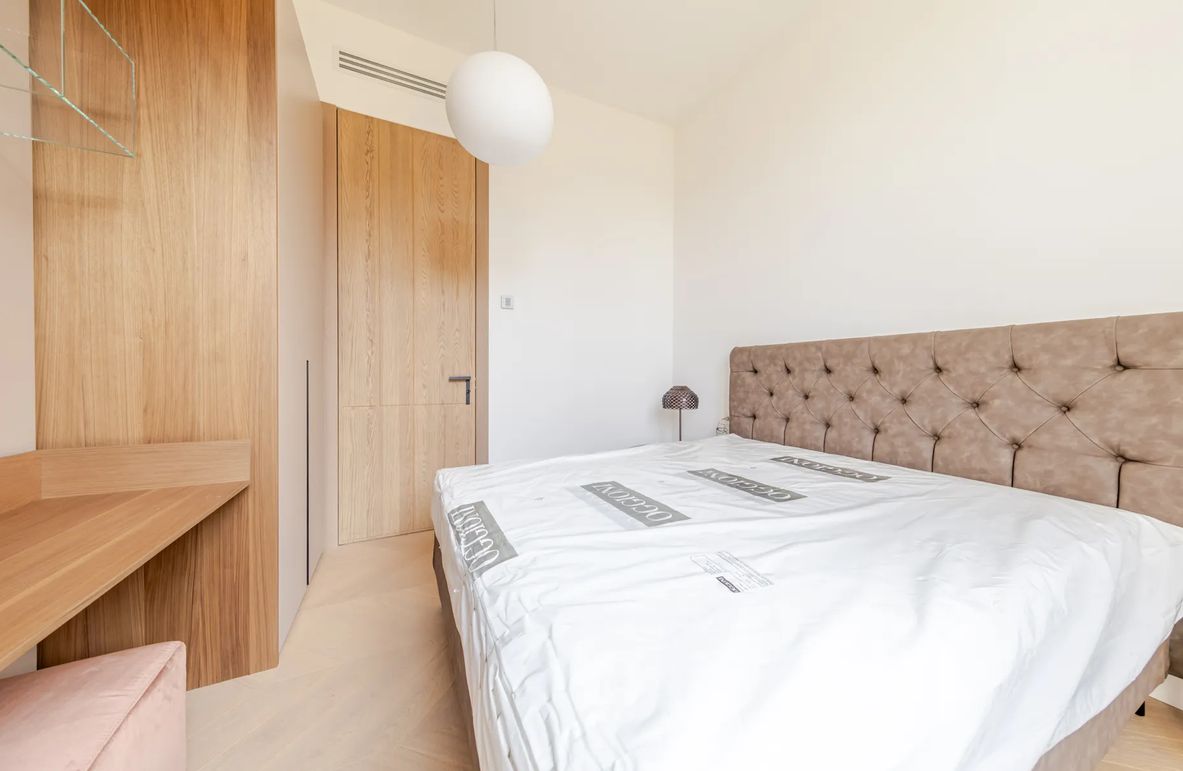 Ein Schlafzimmer mit einem Bett, einem Kleiderschrank und einer Nachttischlampe.