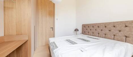 Ein Schlafzimmer mit einem Bett, einem Kleiderschrank und einer Nachttischlampe.