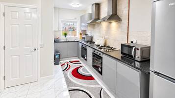 A modern kitchen with stainless steel appliances, a gas stove, and a microwave.