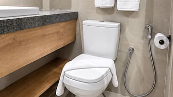 Un baño moderno con inodoro, bidé y toallero.