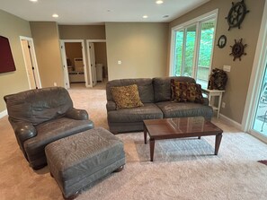 A living room with a leather armchair, a sofa, and a coffee table. - 4Bdrm Lakefront on Quiet Cove. Gradual slope from road to water. (Jacksboro)