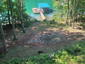 A dock extending into a lake with a small building and lounge chairs. - 4Bdrm Lakefront on Quiet Cove. Gradual slope from road to water. (Jacksboro)