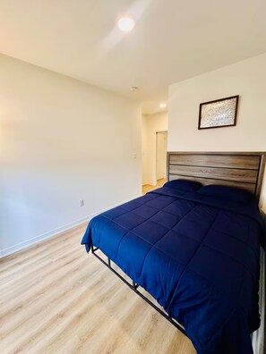A bedroom with a bed, a door, and a light fixture on the ceiling. - Modern & Cozy Townhouse - 2 Bed + 3 Bath w/Parking (Brampton)
