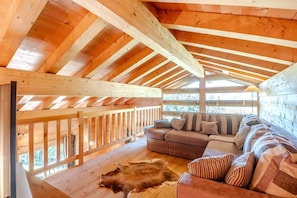 A wooden interior with a high ceiling, a sofa, and a fur rug. - Chalet, 300m from ski slopes, terrace, tv, 124m², Le Grand Bornand (Le Grand-Bornand)