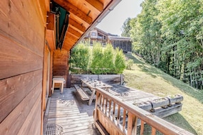 A wooden deck with a table and chairs, a bench, and a railing. - Chalet, 300m from ski slopes, terrace, tv, 124m², Le Grand Bornand (Le Grand-Bornand)