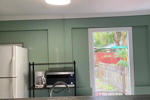 A kitchen with a refrigerator, a coffee maker, and a microwave on a shelf. - Downtown Sarasota House 3br,2ba, Pet-friendly,6ppl (Sarasota)