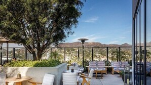 Une terrasse extérieure avec des sièges, une table et une vue sur les montagnes.