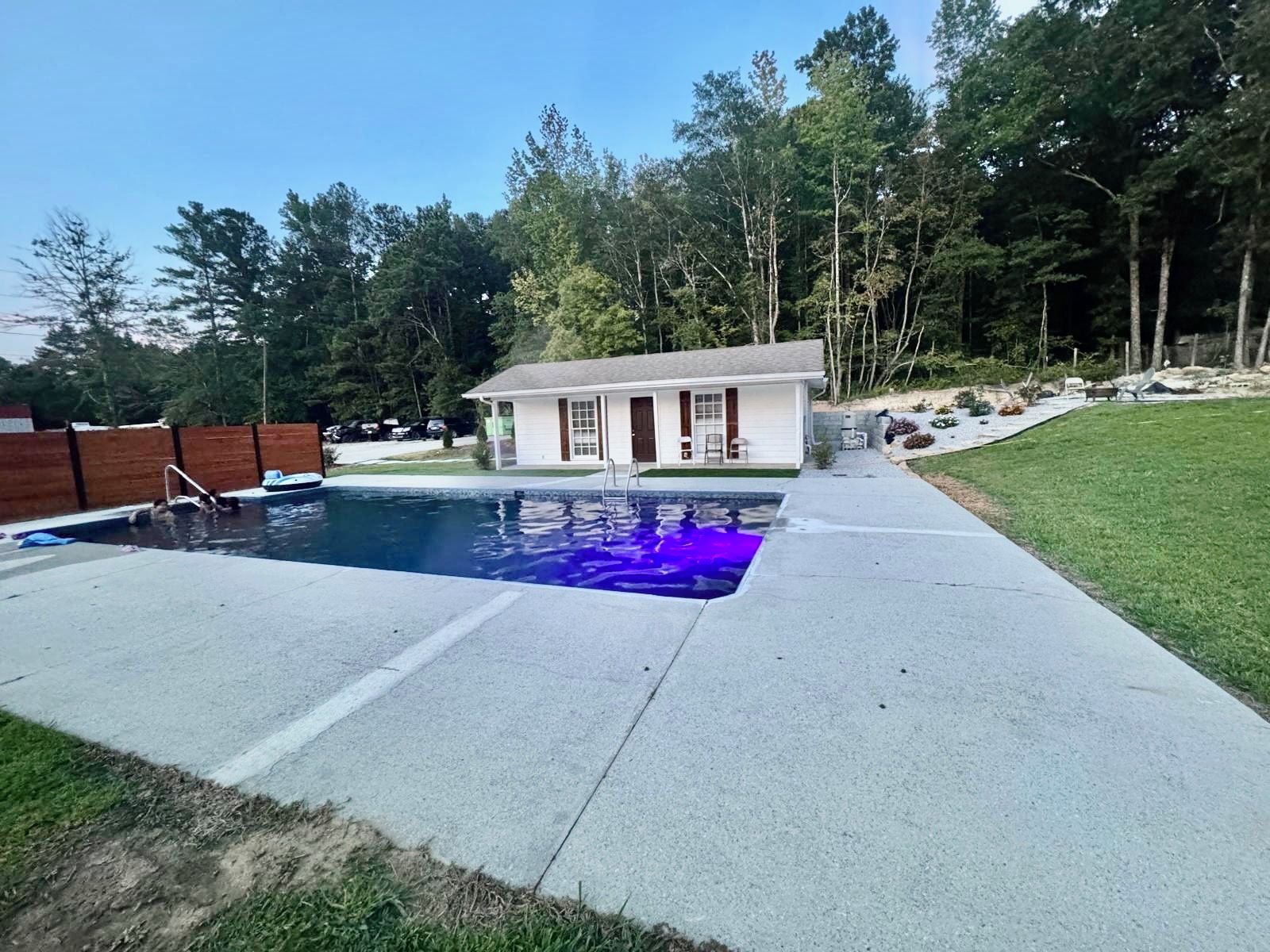 Una piscina comunitària amb una casa al fons.
