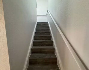 Een trap met houten treden en witte wanden.