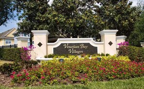 A sign for Venetian Bay Villages with a landscaped garden in front. - Casa familiar de 3 habitaciones con piscina, cerca de Disney (Kissimmee)