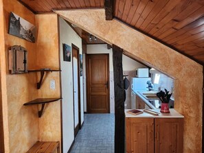 A narrow hallway leading to a kitchen with wooden cabinets and a microwave. - 2nd floor, balcony, parking, tv, 24m², Valloire (Valloire)