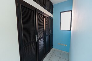A hallway with a blue wall, a window, and a tiled floor. - Central Sosúa Studio: Beaches, Dining & More (Sosúa)