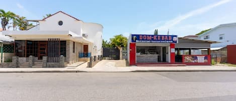 Un bâtiment à deux étages, doté d’un toit plat, dont le rez-de-chaussée abrite un commerce appelé « DOM-KE BAB ».