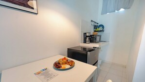 A small kitchenette with a microwave, coffee maker, and a shelf with dishes. A breakfast plate with eggs, bacon, and toast is on the counter. - Studio in the center of Sosua (Sosúa)