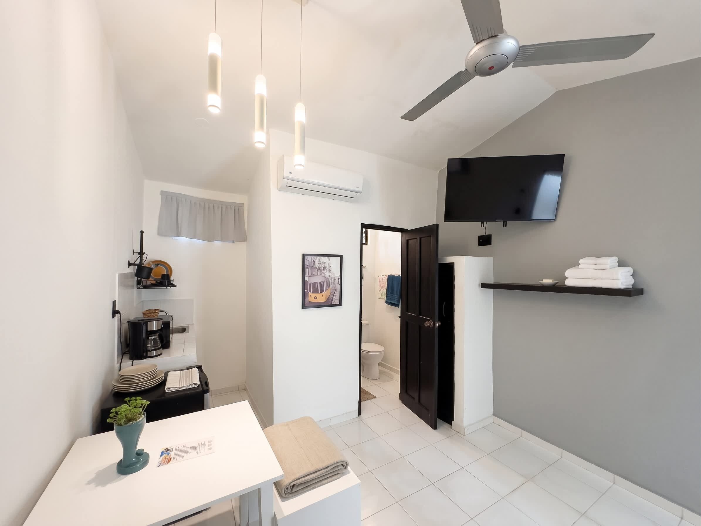 Un baño moderno con inodoro, lavabo y zona de ducha.